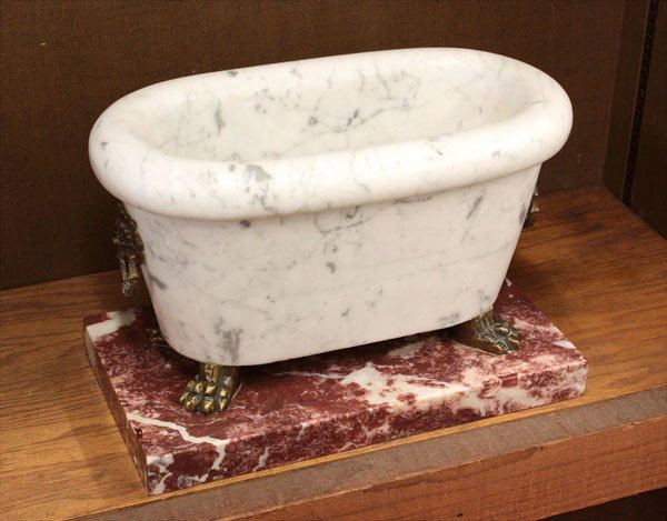 Classical style carrera marble wine coolers: (lot of 2) Pair of classical style carrera marble wine coolers, each with bronze lion head ring handles, raised on bronze paw feet, terminating in a variegated burgundy marble plinth, 11''h x 16''w x 