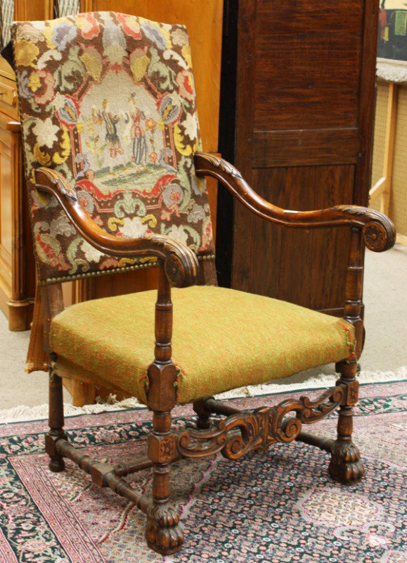 Continental carved throne chair: Continental carved throne chair circa 1860, the padded back having a needlepoint cover depicting a floral frieze centering the medallion of a courting couple, having acanthus carved arms with rosette 
