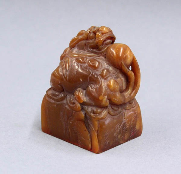 Chinese Soapstone Seal, Qi Baishi: Chinese caramel colored soapstone seal, fashioned with a mythical beast with its head turned toward a sacred jewel set on its back, the tapering plinth incised 'Xianfeng gengshen liu yue' (=1856.6) an