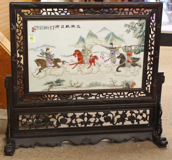 Chinese Decorated Porcelain Plaque, Table Screen: Chinese polychrome enameled porcelain plaque set as a small free standing screen, 20th century, the plaque decorated with three heroes on horseback in battle with Lu Bu, the upper left titled 'San yin