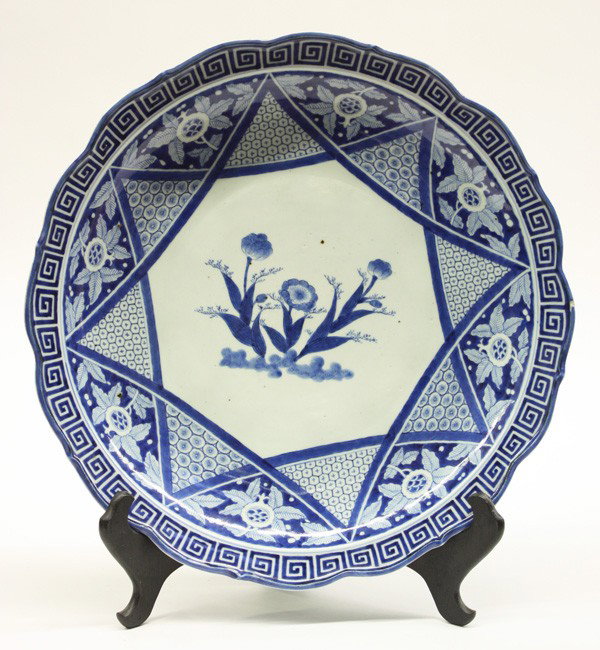 Japanese Arita Style Large Charger: Japanese Arita style large foliate-edged charger, the interior well painted in shades of cobalt blue with flowering sprays within an octagonal border edged by patterned triangles framing stylized pome