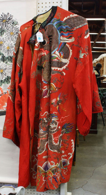 Chinese Embroidered Silk Theatrical Robe: Chinese embroidered theatrical robe, the red silk ground couched with stylized dragons and phoenixes in metallic wrapped threads and further brightened by colored threads all set above mountains and r