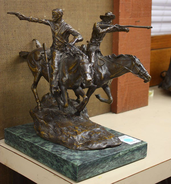 Bronze sculpture, after Remington: Bronze sculpture after Frederic Remington, depicting two armed horsemen with firearms raised, signed on base, Frederic Remington, and raised on a marble plinth