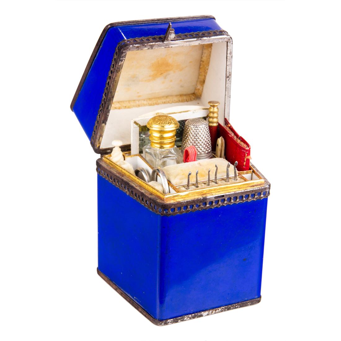 A metal mounted enamel ladies' necessaire: A metal mounted enamel ladies' necessaire, late 19th century, the interior fitted with glass scent bottle, pencil, needles, needlecase, scissors, carved bone tools, 4.5"h x 3.25"w x 2.5"d