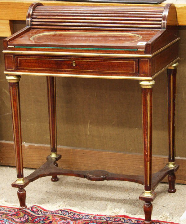 Empire style tambour desk: Empire style mahogany tambour desk, the tambour roll top opens to reveal a fitted interior controlled by the single drawer, having a hinged flip top with a later felt writing surface, and rising on br