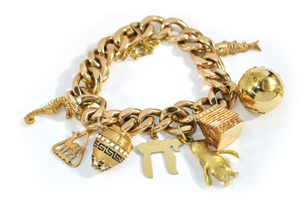 Yellow gold charm bracelet: 18k yellow gold link bracelet with charms; having (4) 14k yellow gold charms and (4) 18k yellow gold charms of a sea horse, globe, penguin, etc. Total weight of bracelet and charms 126.3 grams. Bracel