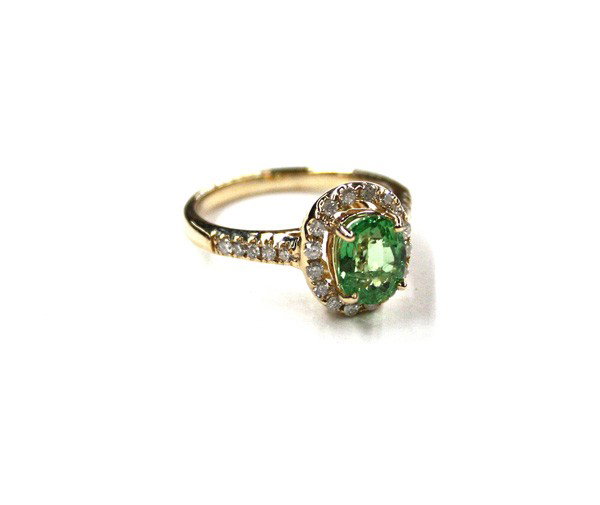 Yellow gold tsavorite diamond ring: Tsavorite and diamond ring; mounted in 14k yellow gold, set with (1) oval tsavorite weighing 1.87 cts and (26) round full cut diamonds weighing 0.40 ct. Total ring weight 4.70 grams. Ring size 6.75