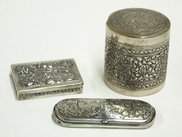 Silver humidor, cigarette box, glasses case: (lot of 3) silver articles consisting of a .900 humidor elaborately created with scrolling acanthus in relief with a wood lined interior, 3.25''h x 3''diam.; a wood lined cigarette box having a hinged