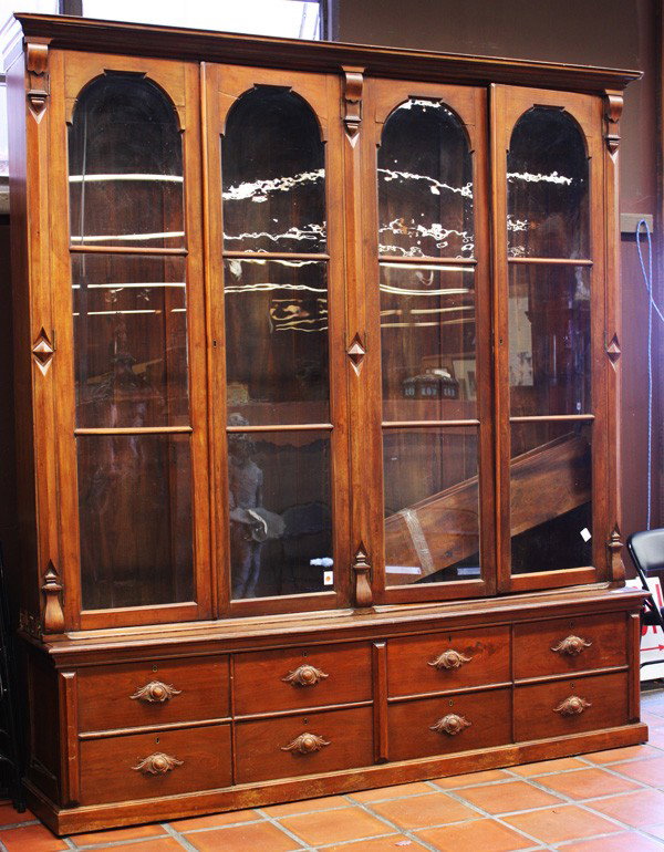 Victortian walnut library bookcase: Victorian walnut libary bookcase, with a rectangular moulded cornice, below are two pairs of glazed doors (four), enclosing shelves, the lower part with eight drawers, four drawers in two groups, divi