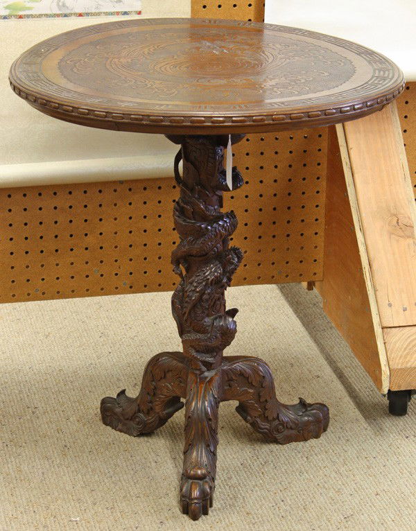 Japanese Wooden Tea Table: Japanese export carved wood tea table, Meiji/Taisho period, the circular top carved with swirling waves on a granulated ground in low relief framed by a key-fret band, set above a pedestal base entwin
