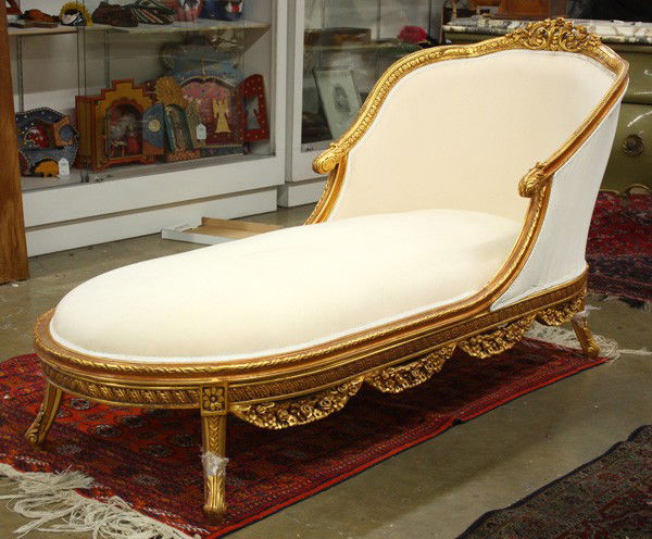 Gilt carved chaise lounge: Gilt carved chaise lounge, the scrolling and carved crestrail continuing to the sloping arms terminating at the acanthus carved returns and rising on stylized cabriole legs, 39.5''h x 29.5''w x 77''l