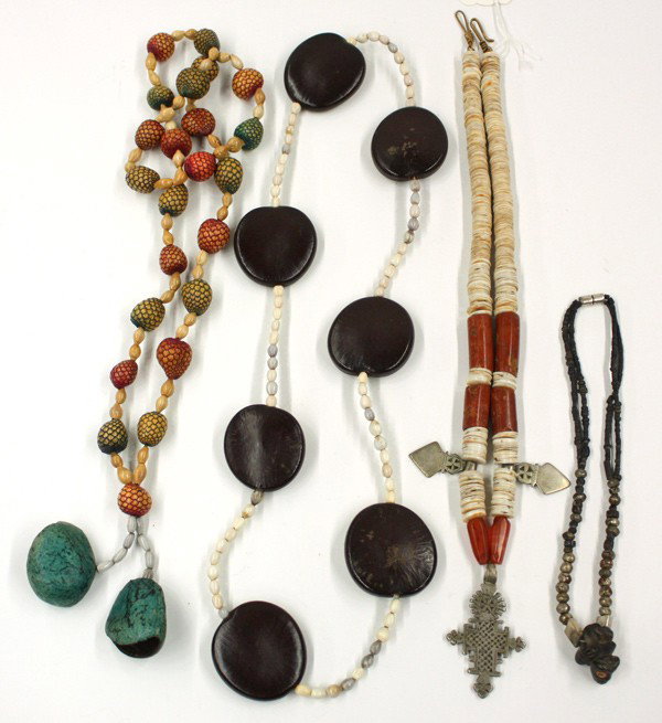 African/Ethnographic Necklaces: (lot of 4) Four necklaces, consisting of: a silver Coptic cross suspended from a strand of shell and carnelian beads; an African bird fetish on a necklace of silver and small black beads; and two neck