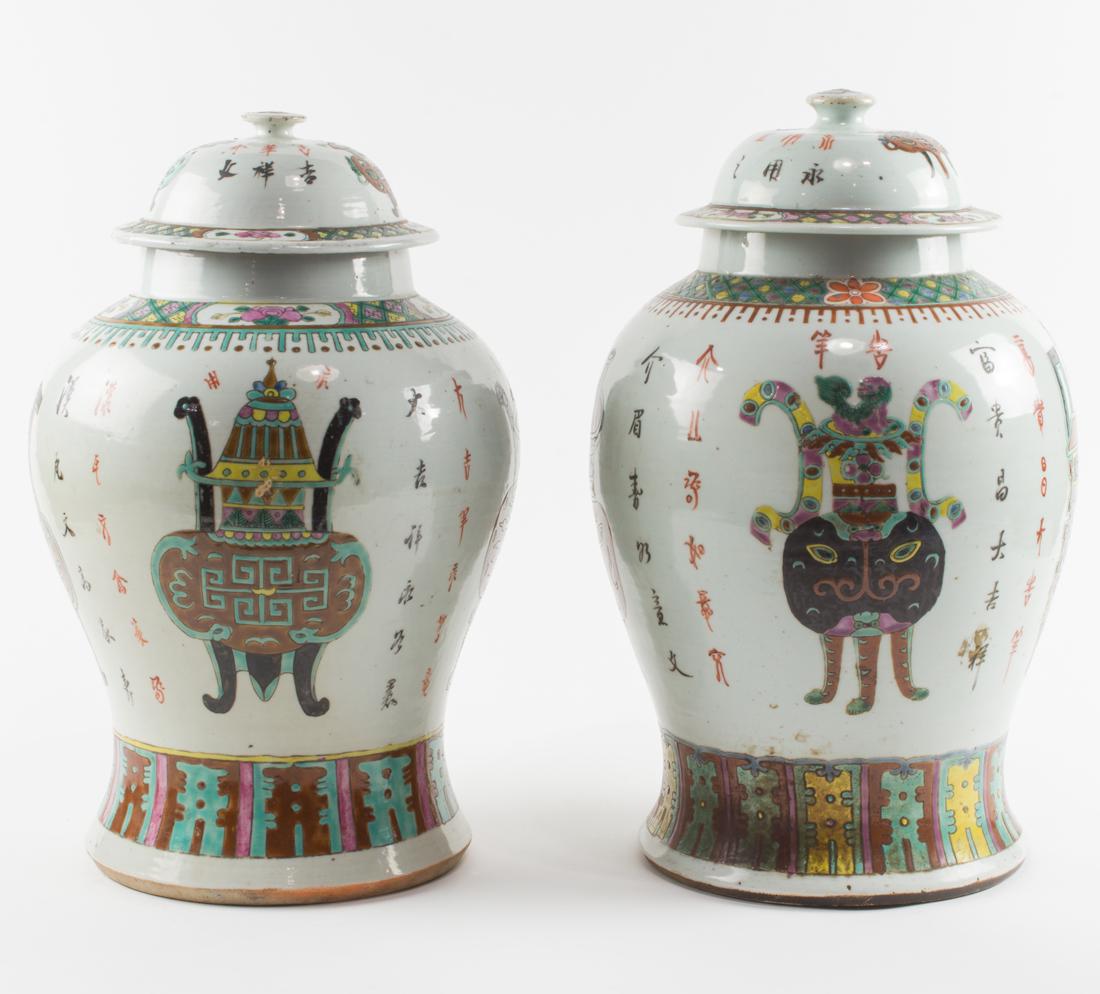 Pair of Chinese famille rose covered temple jars: Pair of Chinese famille rose covered temple jars, decorated with the Hundred Antique design, inscribed with auspicious characters, the shoulders painted with a decorative band featuring peony blooms, 