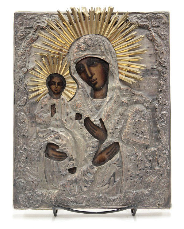 Eastern European icon: Eastern European icon, circa 1960, the riza with a silver toned metal and gold toned metal halo, with chassed decoration and cyrillic text, depicting the Madonna and Christ using lithography, largest 
