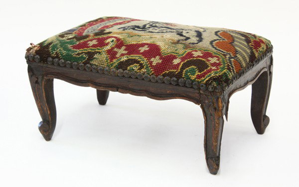 Louis XV style footstool: Louis XV style footstool, circa 1860, upholstered with needlepoint design of a prancing animal in the central field, raised on four carved cabriole legs, the underside of the stool has a period image 