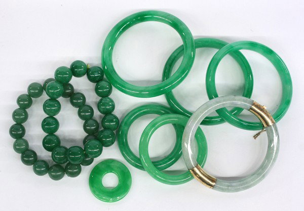 Chinese Jade Bangle Bracelet: Chinese hinged jade bangle bracelet, the stone of a mottled sea-green hue fitted with 14 karat gold mountings decorated with a foliate pattern, overall: 2.8''