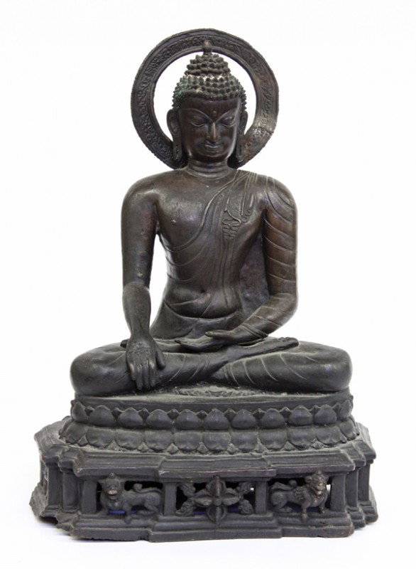 Nepalese Patinated Bronze Buddha: Nepalese patinated bronze figure of the historical Buddha, depicting Sakyamuni exhibiting the bhumisparsa mudra ('calling the earth to witness'), the slender figure wearing monastic garb and seated in