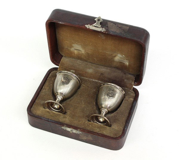 Coin silver egg cups: Pair of American engine turned coin silver egg cups, circa 1850-1860, having a gilt washed interior, central shield showing a scripted monogram, in a fitted case, 2.1 oz.