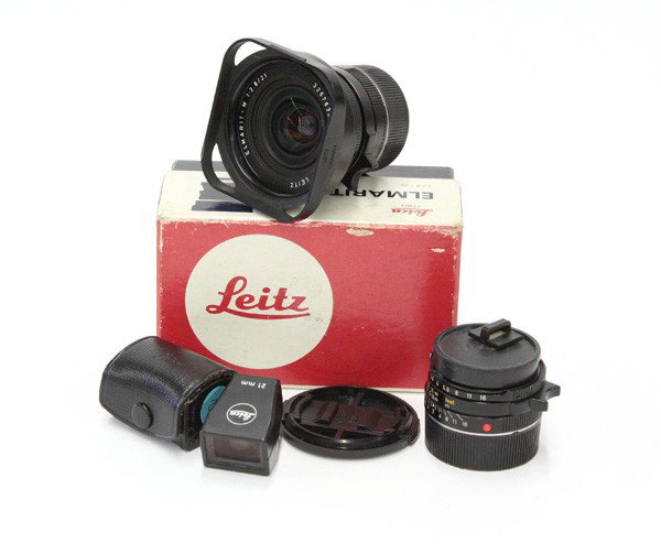 Leica M series lenses: (lot of 4) Leica M series lenses including a Leica Leitz Elmarit 21mm f 2.8 lens, serial #3267630, together with the Leica 21mm hot shue view finder in case, Leica Leitz Summicron 35mm f2 lens, serial