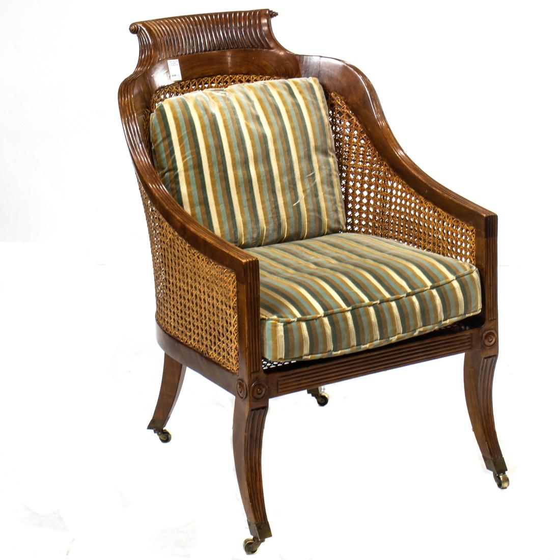 A French bergere circa 1900: A French bergere circa 1900, having a carved crest above the hand caned seat and back foundation, and rising on outswept legs terminating on casters, 35"h x 23.5"w x 20"d