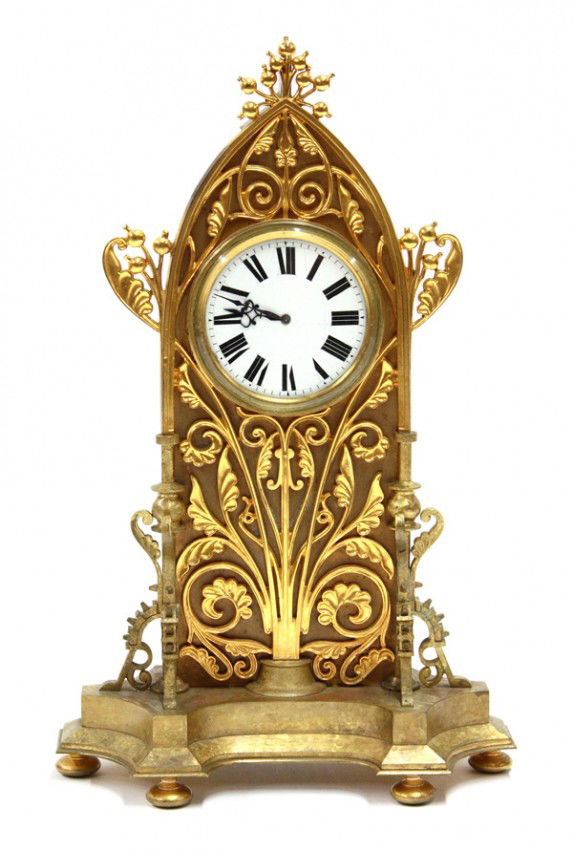 Tiffany and Company mantle clock: Tiffany & Co Gothic mantle clock, executed in gilt bronze and having a floral detail centering the Doxa, Switzerland 15 jewel movement fronted with an enamel face with Roman markers, the sides with co