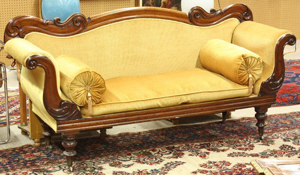 Empire settee: Empire walnut settee circa 1840, the serpentine crestrail with relief carving terminating at the swans neck arms having conforming returns and rising on turned legs