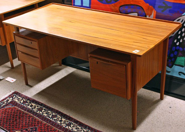 Danish teak executive desk: Danish teak executive desk, circa 1970, with a floating surface, and a tapered back edge, below on either side are two cabinets of equal size, the left side has three drawers, one drawer is lockable,