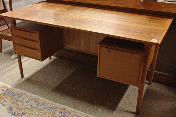 Danish teak executive desk: Danish teak executive desk, circa 1970, with a floating surface, and a tapered back edge, below on either side are two cabinets of equal size, the left side has three drawers, one drawer is lockable,