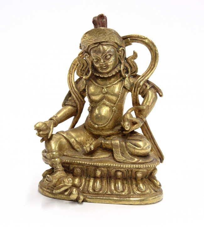 Sino-Tibetan Gilt Metal Buddhist Figure, Kubera: Sino-Tibetan gilt copper-alloy figure of Vaisravana/Jambala/Duo Wen Tian, the 'God of Wealth' seated in a pose of 'royal ease' on a double-lotus pedestal, his left hand with a mongoose expelling jewel