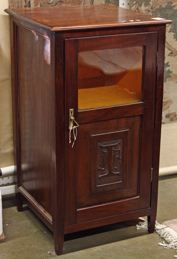 English music cabinet: Edwardian music cabinet, executed in mahogany and having a single door with a carved reserve opening to a fitted interior and rising on tapered legs, 33''h x 18'' square