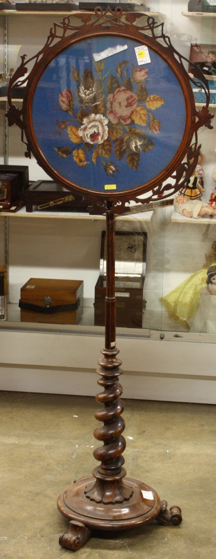 Victorian rosewood needlepoint screen: Renaissance Revival needlepoint screen circa 1860, executed in rosewood and having a scroll carved border surrounding the floral needlepoint panel and rising on a barley twist standard terminating at