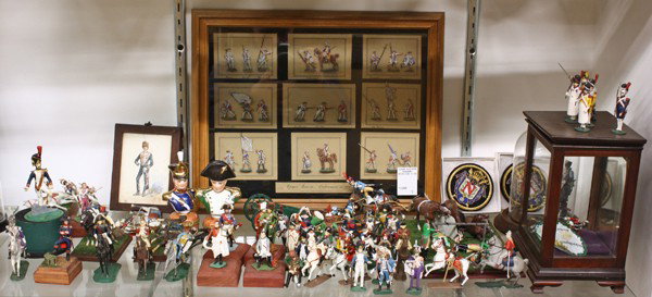 Napoleonic lead soldiers, & associated items: (2 shelves) Napoleonic model soldiers, and associated items, including a framed portrait of Napoleon, a pair of wall hangings of French Napoleonic soldiers, a framed Hussar with the initials RW 1885, 