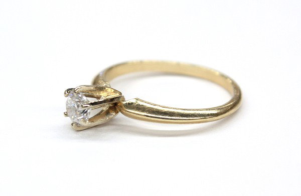 Yellow gold diamond solitaire ring: Diamond solitaire ring; mounted in 14k yellow gold, set with (1) round diamond weighing 0.33 ct (displaying: M color, I1 clarity). Total ring weight 2.0 grams. Ring size 5.25
