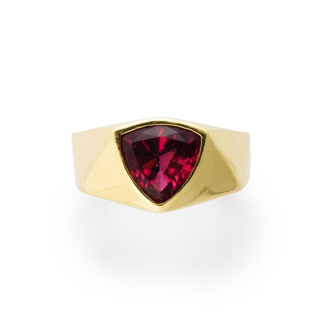 A pink tourmaline and eighteen karat gold ring: A pink tourmaline and eighteen karat gold ring designed as a bezel-set triangular-cut pink tourmaline, measuring approximately 9.10 x 9.20 x 5.10 mm, on geometric-faceted band. 7.6 dwt; size: 7