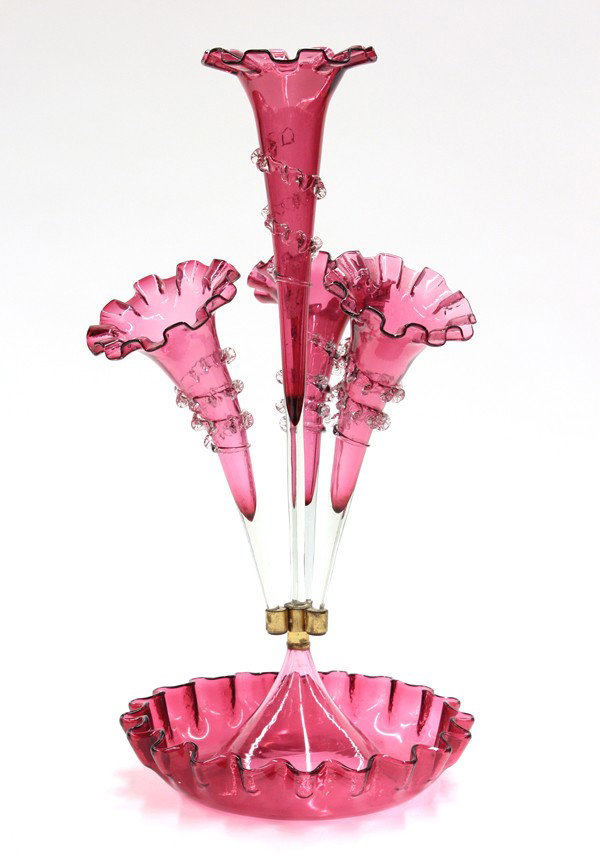 Victorian cranberry glass epergne: Cranberry glass epergne circa 1870, the trumpet forms having applied clear glass detail surrounding the cranberry bodies, each terminating at the brass fitter rising from the circular reservoir, 20''h