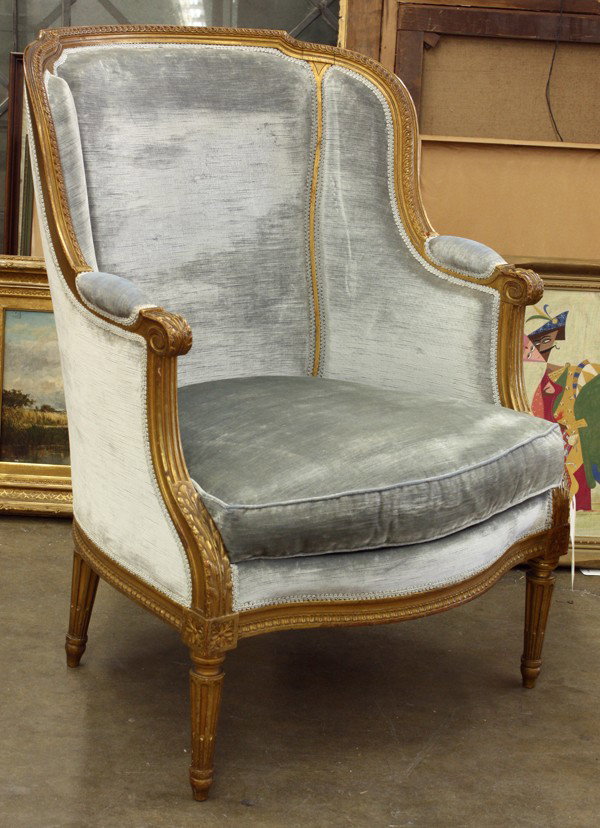 Louis XVI style bergere: Louis XVI style gilt carved bergere, circa 1930, upholstered in baby blue velvet having shaped back with downswept arms and carved acanthus accents raised on tapered and fluted legs