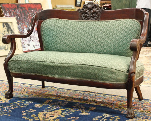 Late Victorian settee: Late Victorian upholstered settee circa 1900, having a serpentine crest rail centered with a relief carved figural medallion continuing to the down swept arms and rising on cabriole legs terminating o