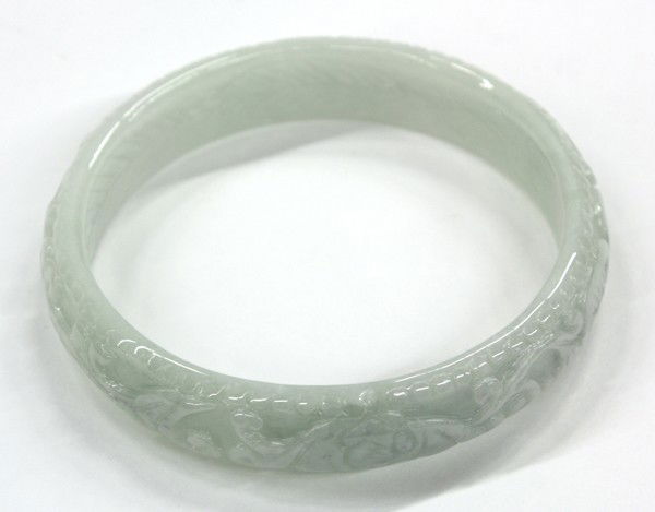 Chinese Jade Bangle Bracelet: Chinese carved jade bangle bracelet, the exterior featuring an auspicious bat together with lingzhi and scrolling tendrils and bracketed by a beaded edge, the interior further incised with a foliate p