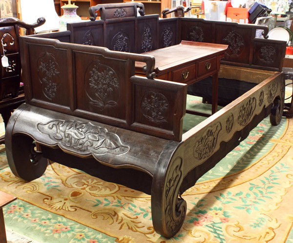 Chinese Carved Wood Day Bed: Chinese dark-stained wooden day bed, Republic period, the stepped back rail and side panels ornately carved with various floral sprays in foliate or fruit form reserves, the contoured apron further ca