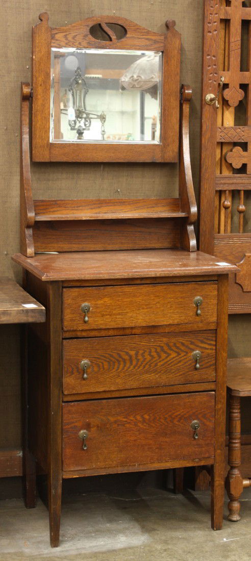 Carved oak shaving stand: Carved oak shaving stand having a framed bevel mirror over a shelf supported on a molded work surface above three drawers with original drop pulls and tapered legs, 64''h x 24''w x 16''d