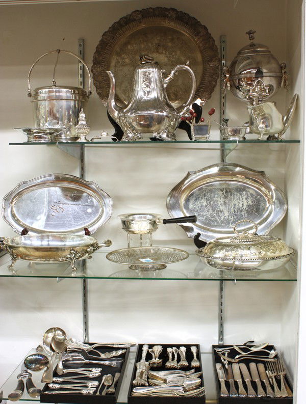 Group of silverplate items: Three shelves having associated silverplate hollowware and flatware including coffee pot, ice bucket, salver, trays, sauce boat, covered vegetable, makers including Reed & Barton, Fisher, Community, W
