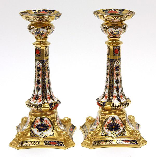 Crown Derby ''Old Imari'' porcelain candlesticks: (Lot of 2) Royal Crown Derby ''Old Imari'' porcelain candlesticks pattern 1128, having a gilt, cobalt and crimson decorated body on a white ground and rising on a graduated plinth, XXXIII marked on ba