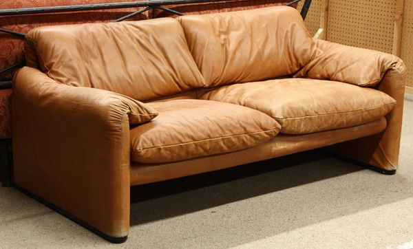 De Sede leather sofa: De Sede sofa, having wrap around arms and back and upholstered in tan leather, 27''h x 65''w x 32''d
