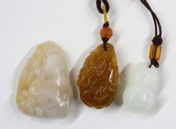 Chinese Small Jade Toggles: (Lot of 3) Chinese small jade/hardstone toggles, the first of a semi-translucent caramel-hued matrix carved as a Buddha hand citron reversed by a lingzhi sprig; the second a white colored double gourd