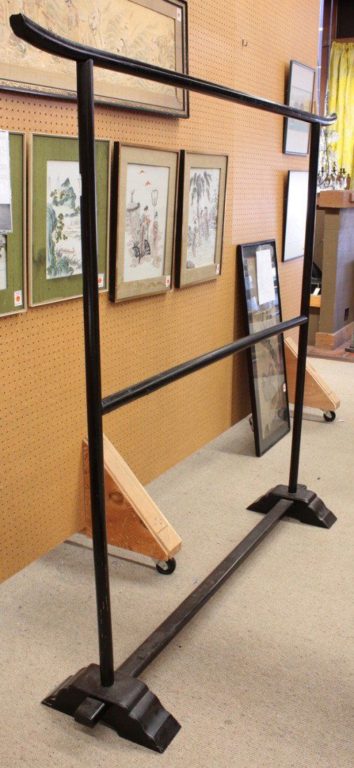 Asian Wooden Clothing Rack: Japanese black lacquered wood clothing rack, the top rail with slightly upturned ends joined to two vertical poles braced by a central horizontal cross member and set into a pair of tiered block suppo