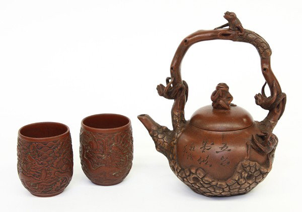 Chinese Yixing group : (Lot of 3) Chinese Yixing red clay teapot, the compressed ovoid body and loop handle overlaid by a pine branch populated by small monkeys, one side with an incised inscription, the base signed 'Chen M