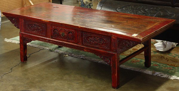 Chinese Red Lacquered Low Table: Chinese red lacquered wooden low table, with a rectangular top over a small floral-carved drawer bracketed by panels featuring pairs of fish, the other side complemented with two drawers flanking the