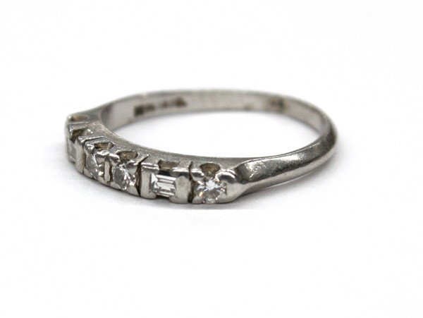 Diamond platinum band ring: Diamond band ring; of platinum, set with (4) round full cut and (2) baguette cut diamonds. Total diamond weight 0.25 ct. Total ring weight 2.9 grams. Ring size 4.25