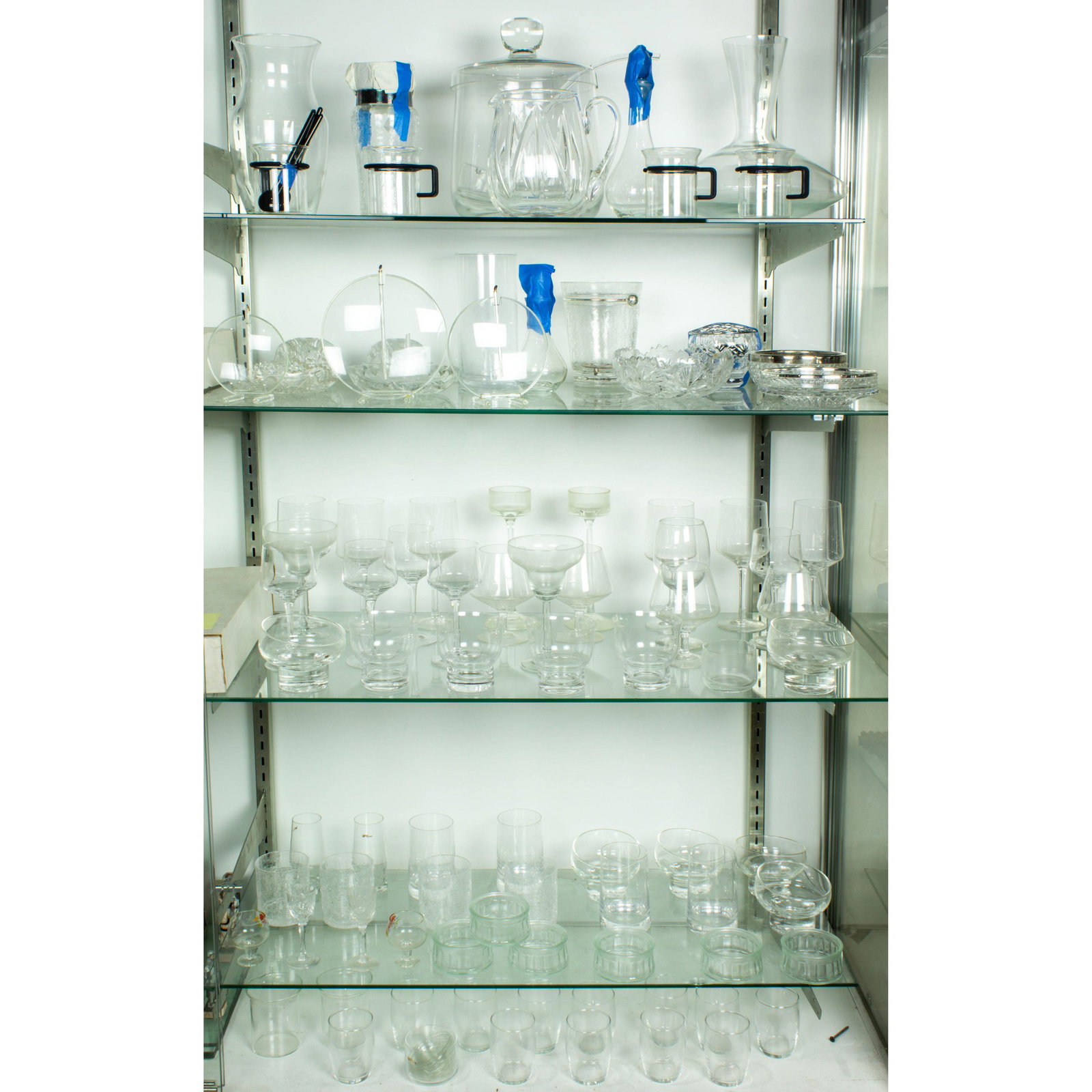 Five shelves of glassware: Five shelves of glassware, including Bodum coffee set, cut glass table articles, various wine glasses and candle holders.