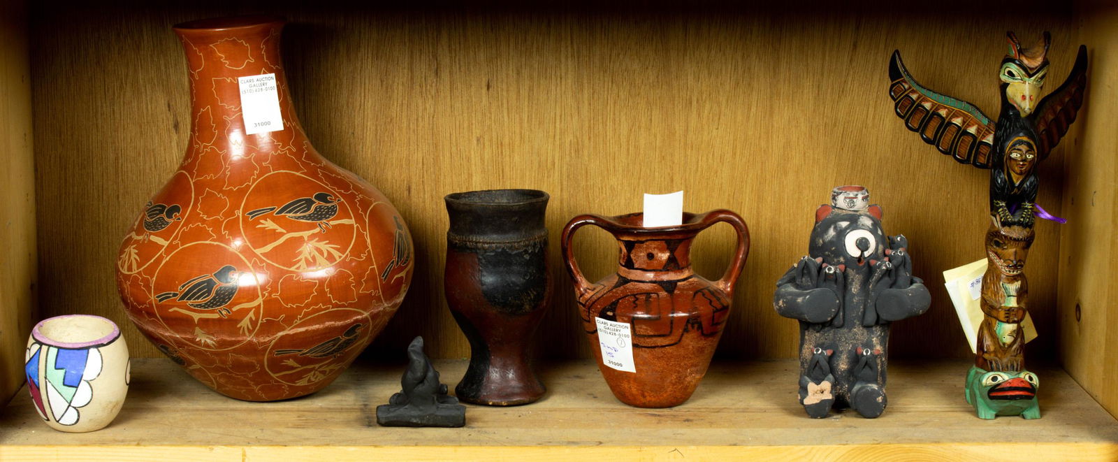 One shelf of mostly pottery including a small vase signed Tesague (1 of 1)